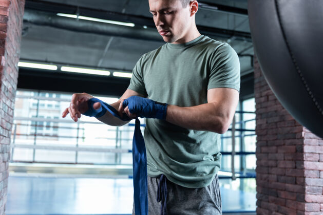 打斗宽敞的健身房漂亮的强壮的战士穿着卡其色衬衫在宽敞的健身房里努力训练健身房男性课