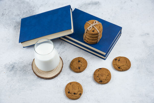 饼干一杯牛奶 巧克力饼干和一本放在大理石表面的书饼干牛奶面包店