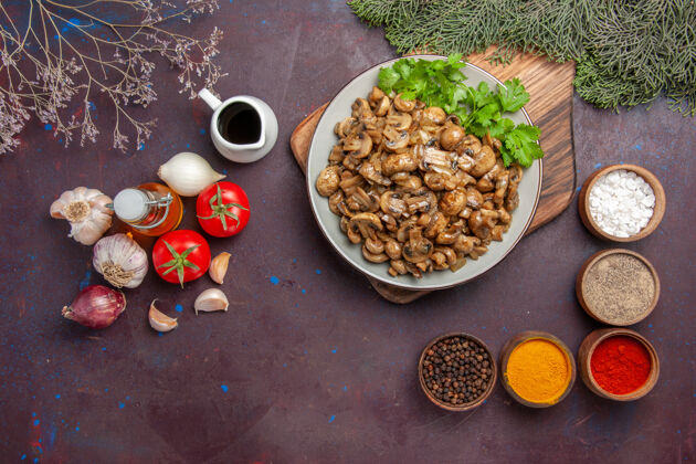 风景俯瞰美味的熟蘑菇配上调味料和蔬菜上的深色背景餐菜晚餐野生植物食物晚餐豆类晚餐