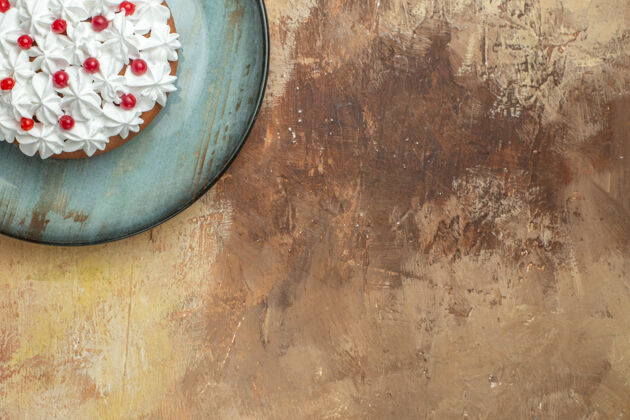 墙壁一半的美味蛋糕与奶油和葡萄干装饰在一个蓝色的盘子在右侧的彩色背景一半背景葡萄干