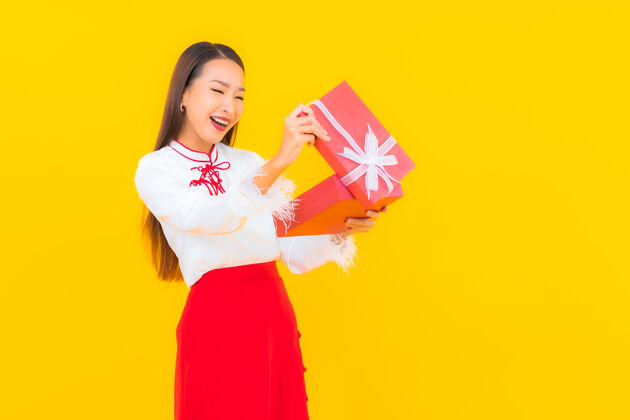 新肖像美丽的亚洲年轻女子与红色礼盒黄色惊喜日本女人