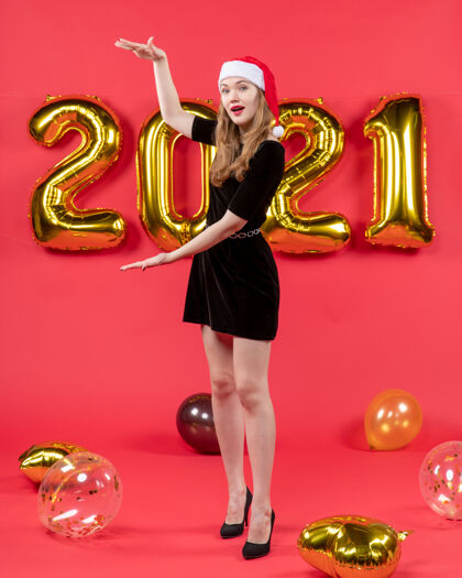 大小正面图：身穿黑色连衣裙的年轻女士 手上拿着红色气球 展示身材前面管乐器黄铜
