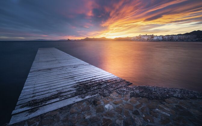 海湾在风景如画的日落中 用木制码头欣赏海景 令人叹为观止天空码头假日