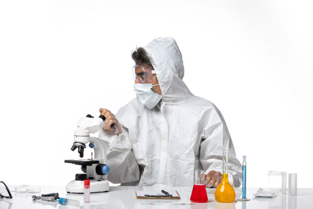 灭菌男医生穿着防护服 带着无菌口罩 白色皮肤上拿着针剂外套视图防护