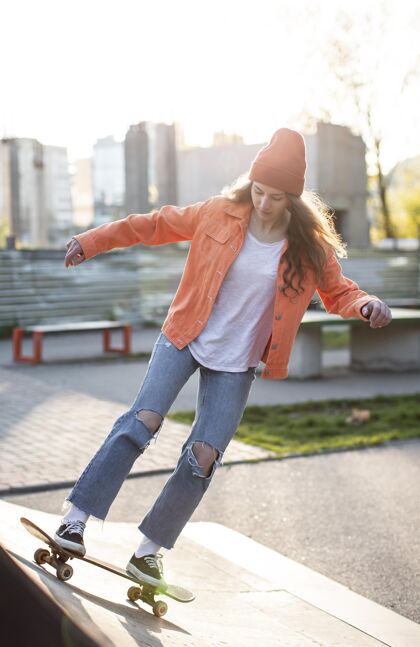 女孩一个在外面玩滑板的年轻女孩全速滑板生活方式