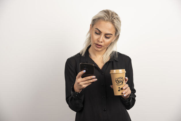 手机女人看手机 拿着一杯咖啡高质量的照片人女人女人