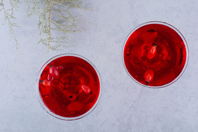 冷的两杯红果汁在石头上果汁玻璃杯浆果