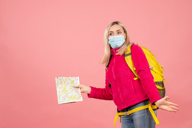 成人正面图旅行妇女背着黄色背包戴着医用面罩拿着地图快乐女士时尚