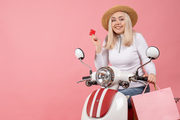年轻女士正面图：一位面带幸福表情的年轻女士 手持轻便摩托车摩托车模型持有