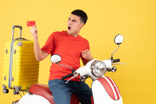 视图正面图：骑着轻便摩托车拿着折扣卡的年轻人持有活跃成人