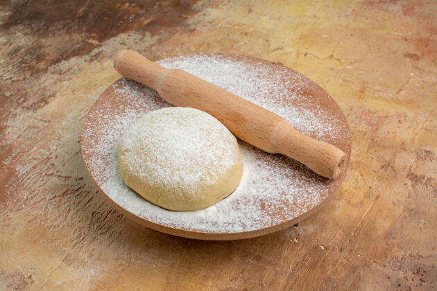 美食前视图生面团切片与面粉奶油桌上的菜肴面食烘焙木勺面包