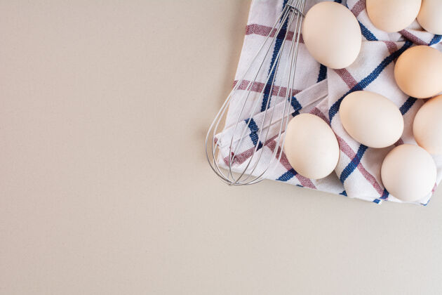 食物新鲜的生鸡蛋放在米色的桌子上新鲜生未经料理的