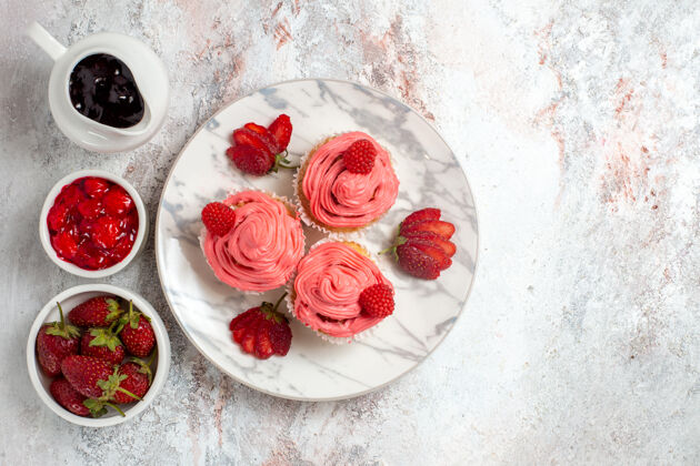 棒白色表面上有果酱和巧克力棒的粉色草莓蛋糕俯视图果酱草莓新鲜