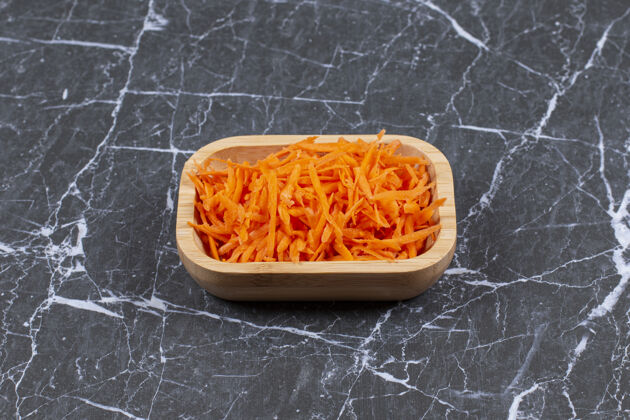 切片把新鲜胡萝卜磨碎放在棕色的木盘里营养生的天然