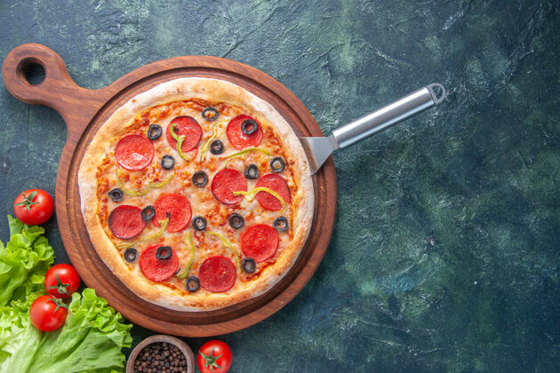 比萨饼美味的自制披萨在木板上油瓶番茄胡椒绿色包在黑暗的表面餐厅炊具板