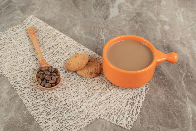 一餐一杯咖啡 饼干放在大理石表面 上面放着咖啡豆勺子木头饼干