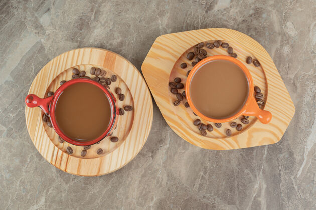 热两杯咖啡和咖啡豆放在木盘上豆烤咖啡
