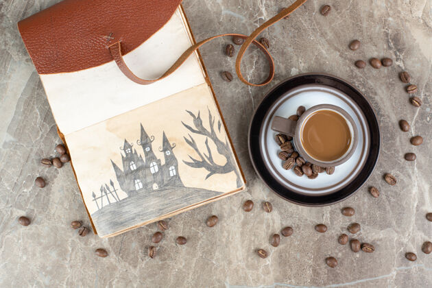 美味咖啡杯 咖啡豆和笔记本放在大理石表面美味营养