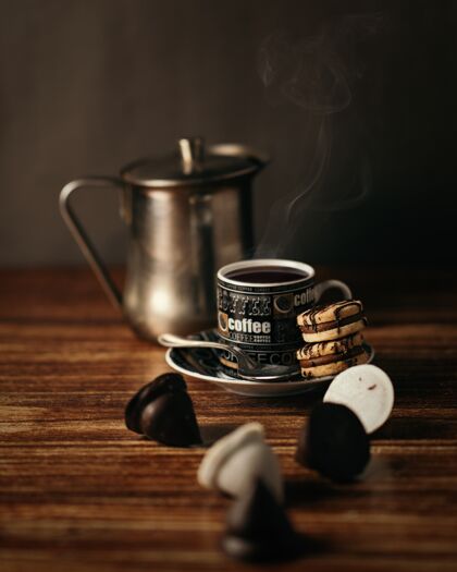 芳香一杯热咖啡和饼干放在桌上的灯下-完美的饮料概念浓缩咖啡杯子
