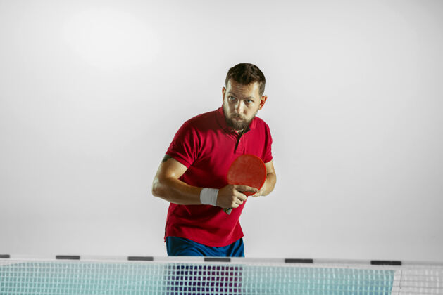 男在白色工作室墙上打乒乓球的年轻人休闲乒乓球白种人