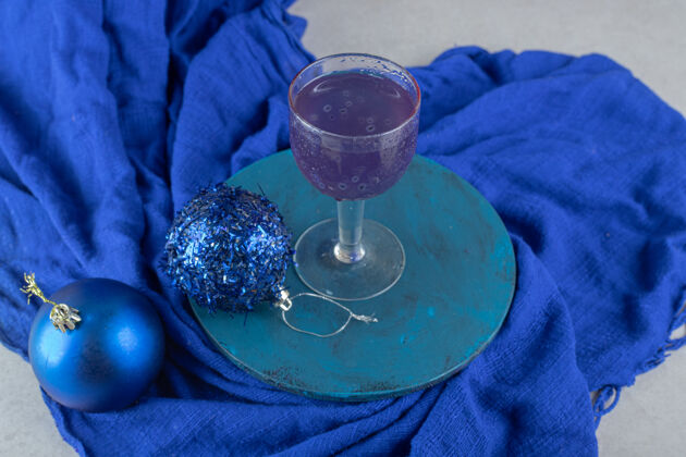 圣诞节蓝色鸡尾酒 蓝色盘子上有闪闪发光的圣诞饰品果汁配料一餐