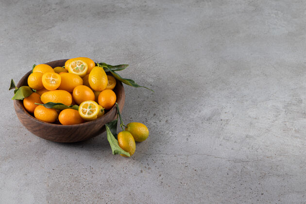 柑橘在石头表面放一碗新鲜多汁的金橘配料多汁有机