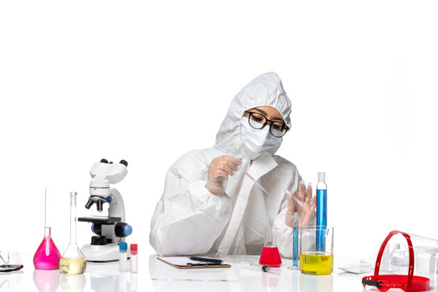 健康前视图穿着特殊防护服的女化学家在一个浅白色背景的病毒冠状病毒化学实验室工作诊所医疗工作