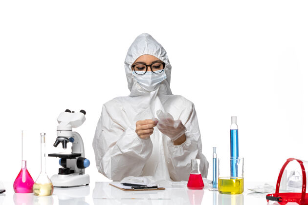 面罩前视图穿着特殊防护服的女化学家坐在白色背景化学大流行性冠状病毒的解决方案女化学家白人前面