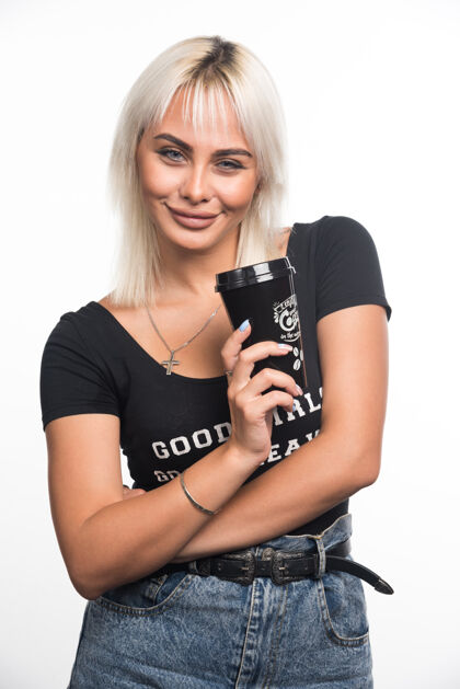 女人年轻女子抱着一杯咖啡在白墙上交叉双臂表达咖啡杯子