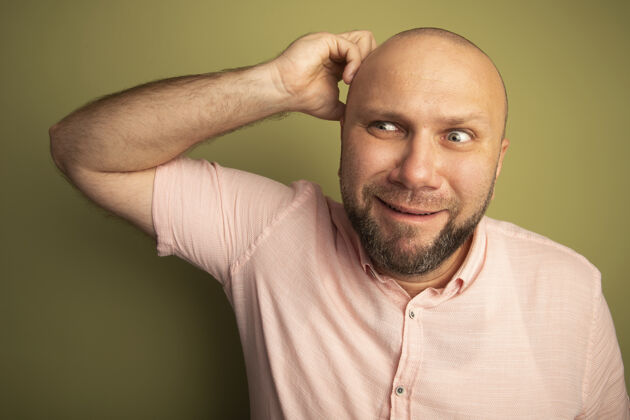 中年印象深刻的看边中年秃头男子穿着粉色t恤搔头秃头男人刮痕