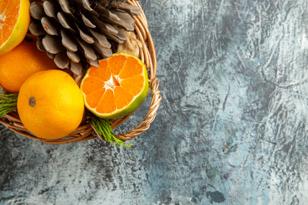 柑橘浅灰色表面上篮子里多汁新鲜橘子的俯视图水果柑橘可食用水果