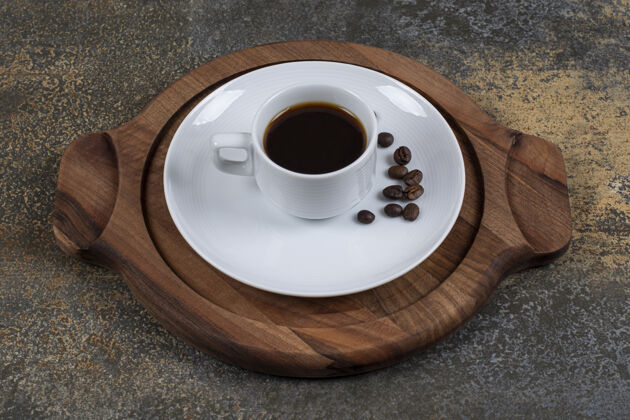 热的一杯咖啡豆加咖啡豆放在木板上新鲜的浓缩咖啡咖啡