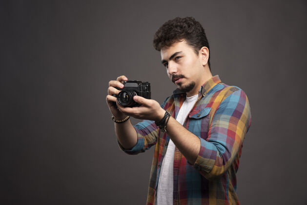 休闲年轻有经验的摄影师认真拍摄专业照片男性生产姿势