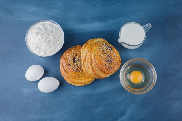 面包房两个美味的传统糕点 蓝色表面有面粉和牛奶曲奇牛奶面包