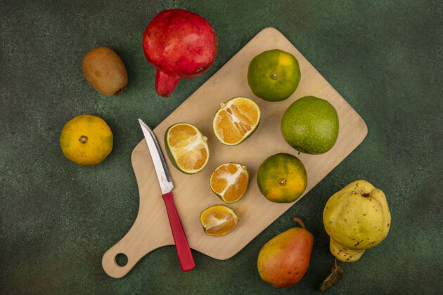 刀顶视图新鲜的橘子在一个木制的菜板与刀美味的水果 如梨石榴等等梨橘子