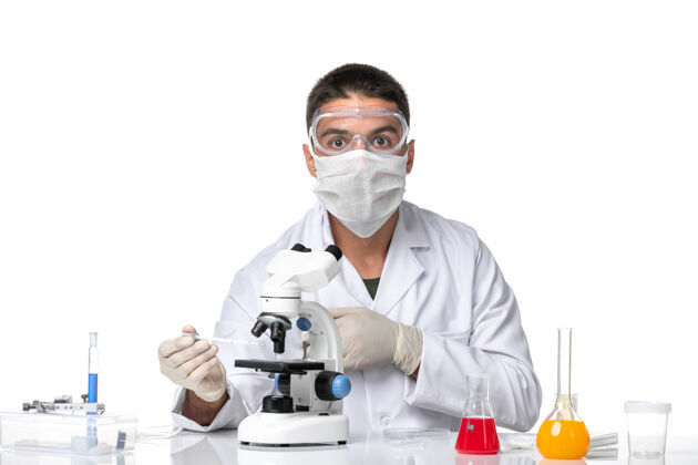 医生正面图：男医生穿着白色医疗服 戴着面罩 戴着隐形眼镜 在浅白的空间里使用显微镜到期面具浅白色