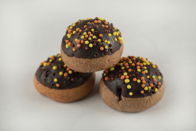 圆形巧克力甜甜圈和五颜六色的花洒颜色糖不同