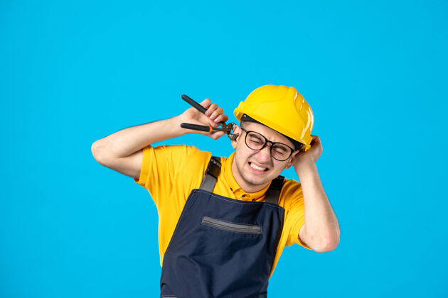 护目镜正面图穿着制服戴着头盔的男工人在蓝色的地板上割耳朵制服服务帽子