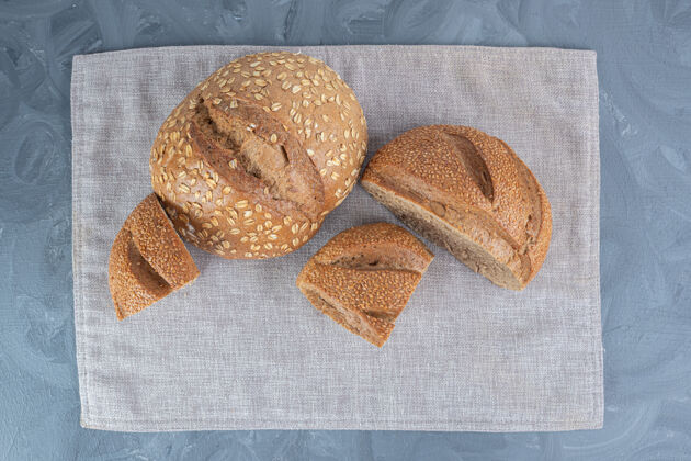 面包芝麻把切成薄片的面包块放在大理石表面的毛巾上切片面包皮芝麻