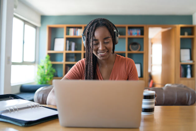 职业一个女人的肖像在一个视频电话与笔记本电脑和耳机 而在家工作的概念专业人士女性无线