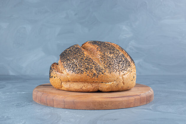 面包盖黑芝麻放在大理石背景的木板面包上美味面包皮黑芝麻