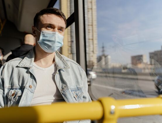 感染预防年轻人戴着口罩坐公交车公共汽车坐姿城市公共汽车