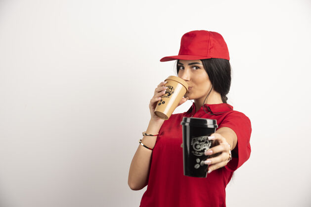 咖啡女信使喝着一杯白色背景的咖啡高质量的照片送货员肖像制服