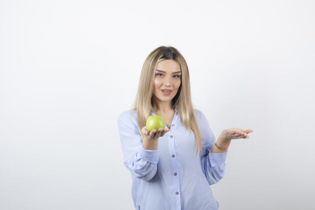 美味一个美丽迷人的女模特站着 手里拿着一个新鲜的绿色苹果的肖像照食物肖像苹果