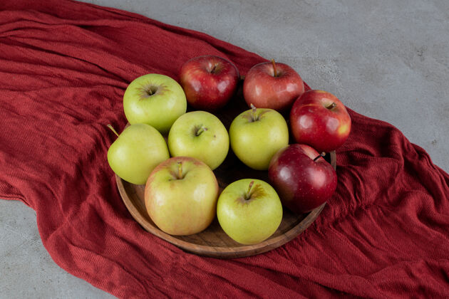 营养两个不同类型的苹果放在大理石表面的托盘上品种托盘美味