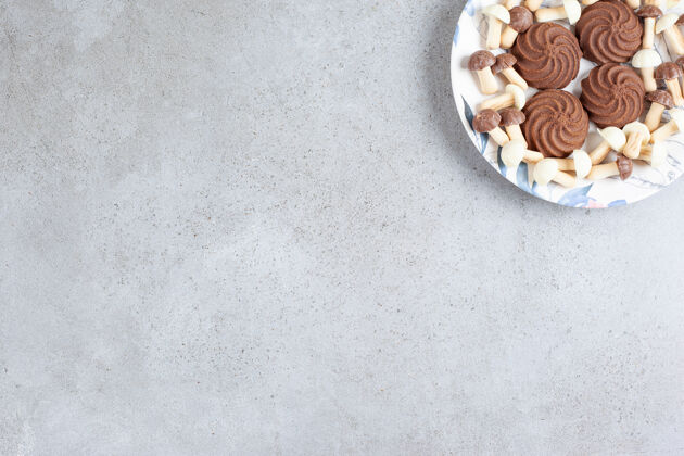 营养饼干和巧克力蘑菇放在大理石背景的盘子里高质量的照片甜点曲奇不健康