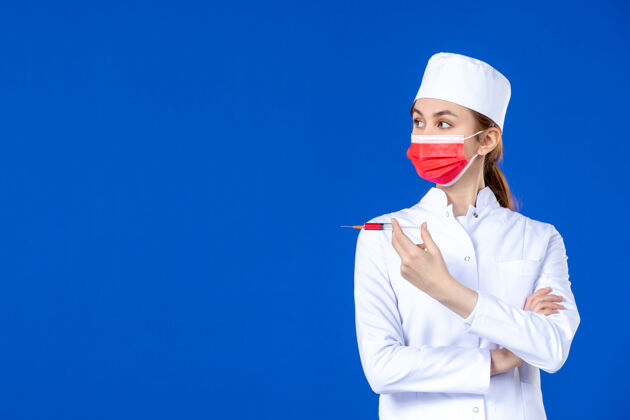 疾病正面图：身穿白色医疗服的女护士 戴着红色面罩 手上拿着蓝色针剂衣服人病毒