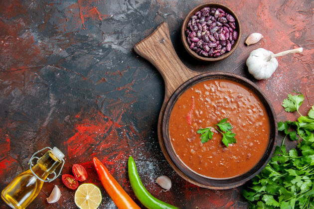 番茄经典番茄汤倒油瓶豆子放在色彩斑斓的菜板上餐厅切午餐