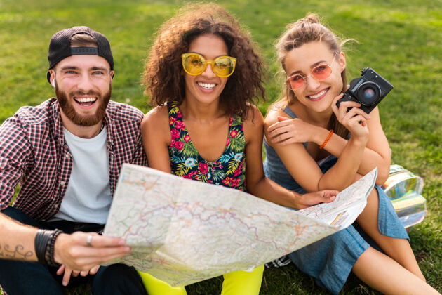 青年快乐的年轻朋友们一起坐在公园旅游 在地图上观光 男女同乐 兴奋团体旅游