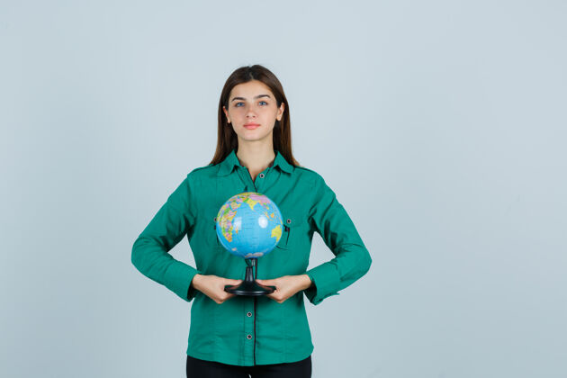地球仪穿着绿色衬衫拿着地球仪的年轻女士 看上去很自信正视图商务欢呼肖像
